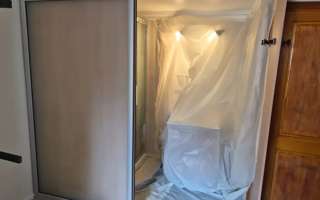 Salle d'eau bâchée avant intervention, cabine de douche protégée