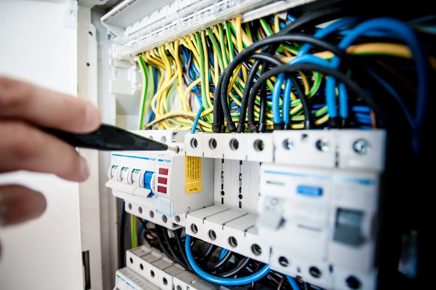 Tableau électrique ouvert, disjoncteurs et câblage repris pendant une rénovation